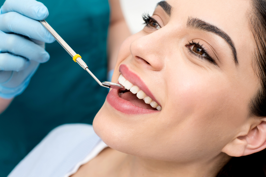 Young woman sitting in a dental chair and smiling while getting a dental exam and dental cleaning at Arlington Pediatric Dentistry in Arlington, WA